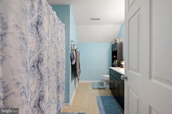 a hallway with white cabinets and wooden floor