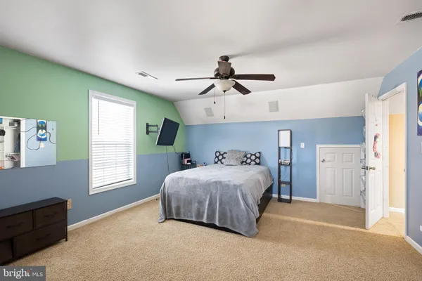 a bedroom with a bed chandelier and a window