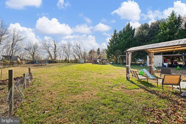 a view of swimming pool with seating area and trees in the background