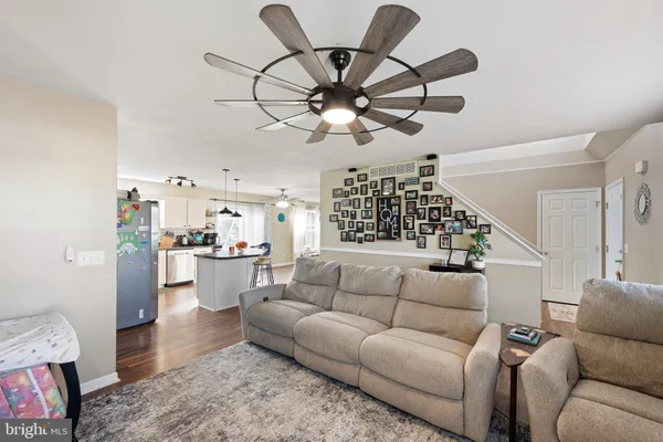 a living room with furniture a ceiling fan and a rug