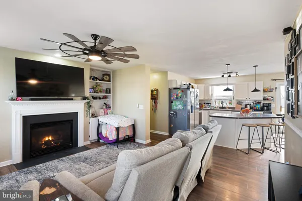 a living room with furniture a flat screen tv and a fireplace