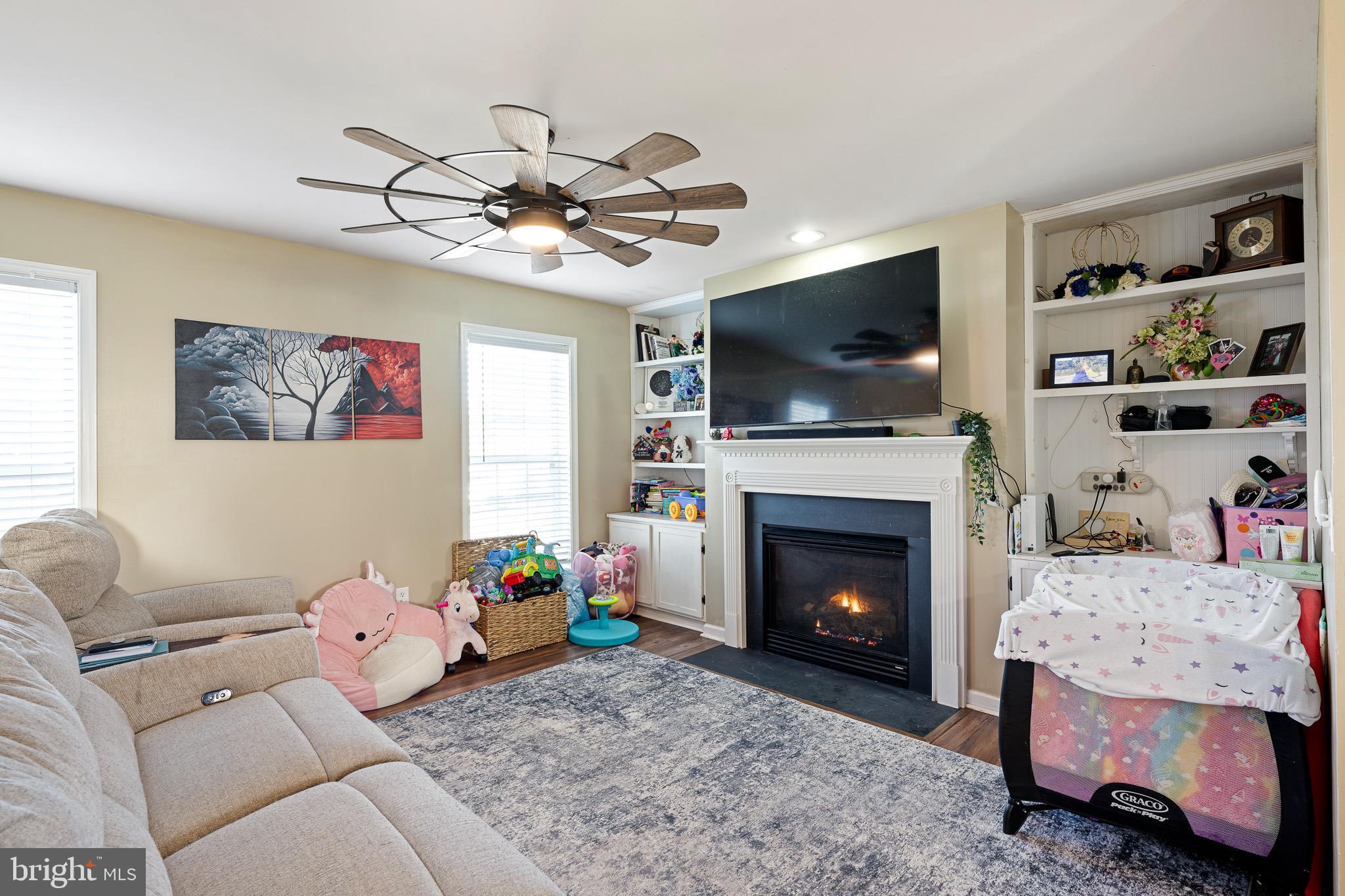 29 East Walnut Street Magnolia, DE 19962 - Photo 6 of 35 a living room with furniture a flat screen tv and a fireplace