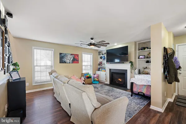 a living room with furniture a flat screen tv and a fireplace