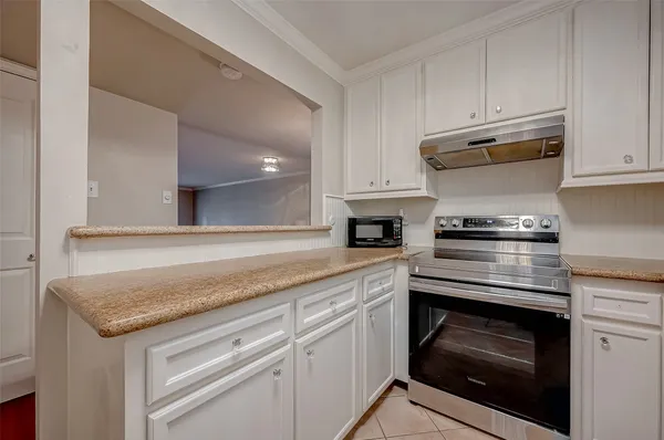a kitchen with granite countertop stainless steel appliances and white cabinets