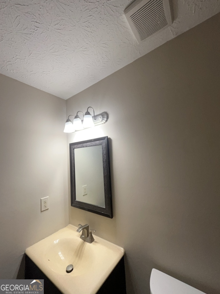 1265 Herrington Road Lawrenceville, GA 30044 - Photo 32 of 52 a bathroom with a toilet sink and mirror