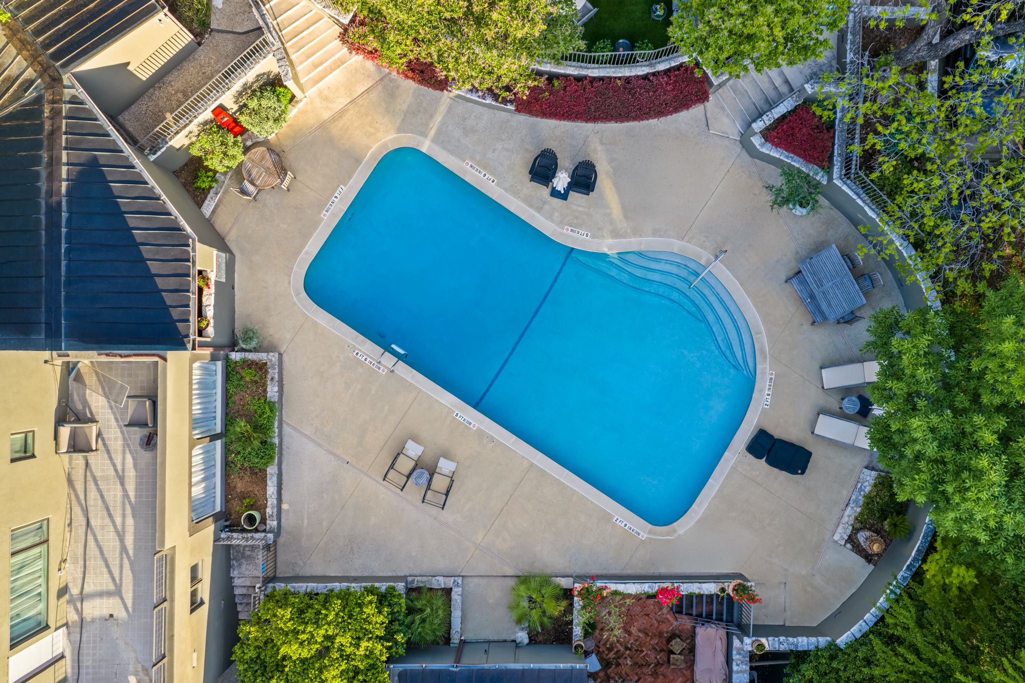 1111 West 12th Street, Unit 107 Austin, TX 78703 - Photo 10 of 38 Curved swimming pool with integrated steps set within a concrete patio