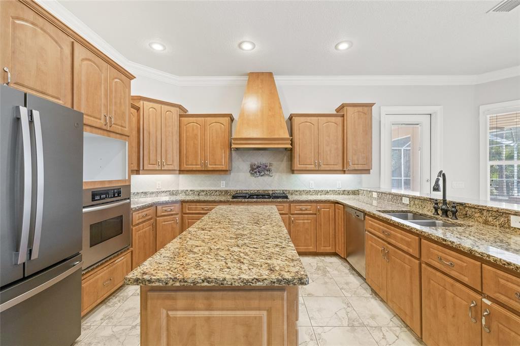 11040 Fulton Avenue Weeki Wachee, FL 34613 - Photo 12 of 77 a kitchen with stainless steel appliances granite countertop a sink stove and refrigerator