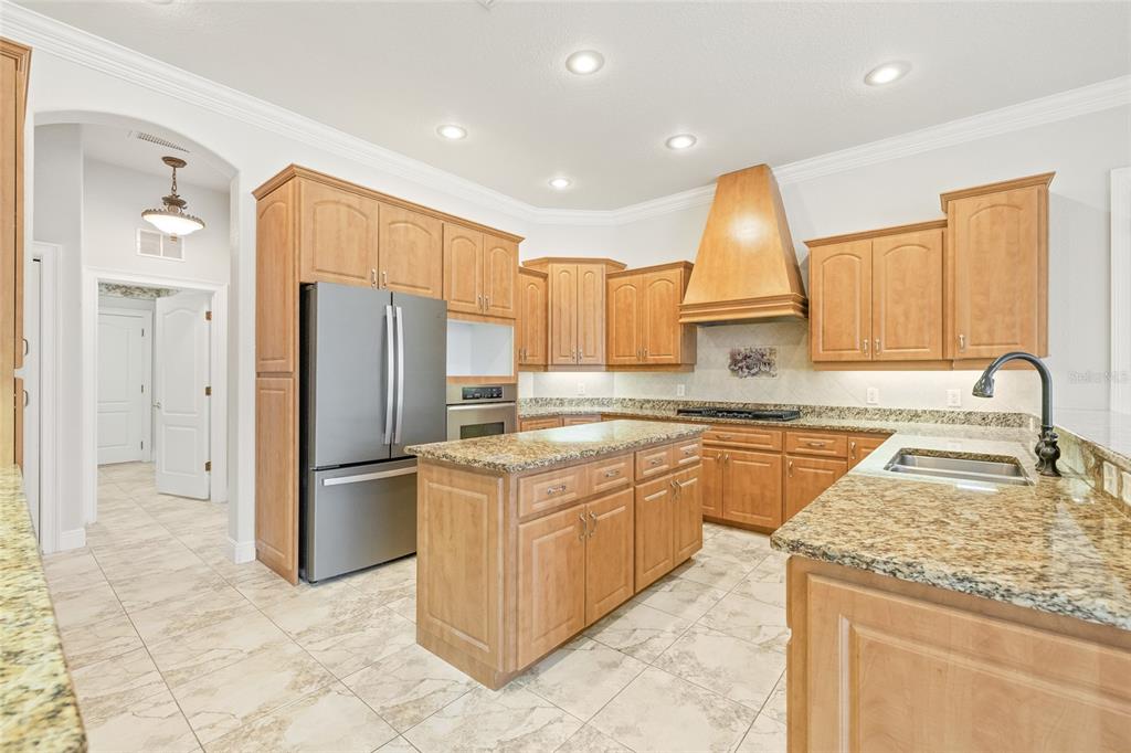 11040 Fulton Avenue Weeki Wachee, FL 34613 - Photo 13 of 77 a kitchen with stainless steel appliances granite countertop a refrigerator sink and cabinets