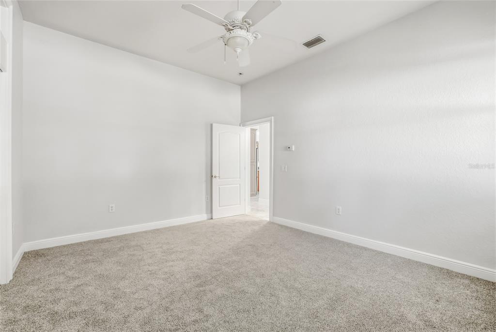 11040 Fulton Avenue Weeki Wachee, FL 34613 - Photo 41 of 77 an empty room with a ceiling fan and carpet