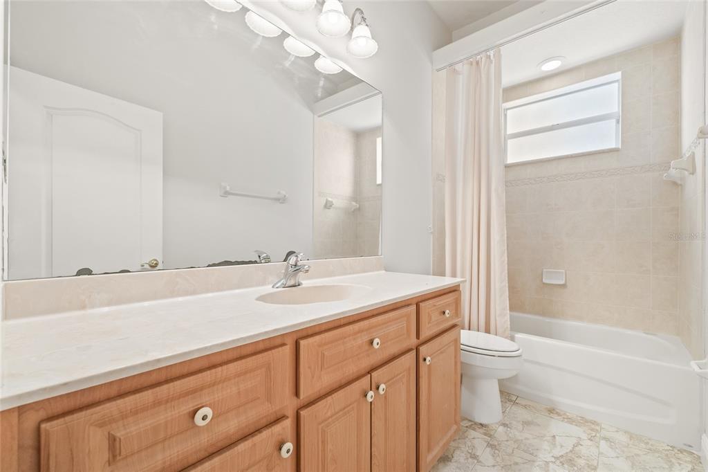 11040 Fulton Avenue Weeki Wachee, FL 34613 - Photo 42 of 77 a bathroom with a granite countertop sink a toilet and bathtub