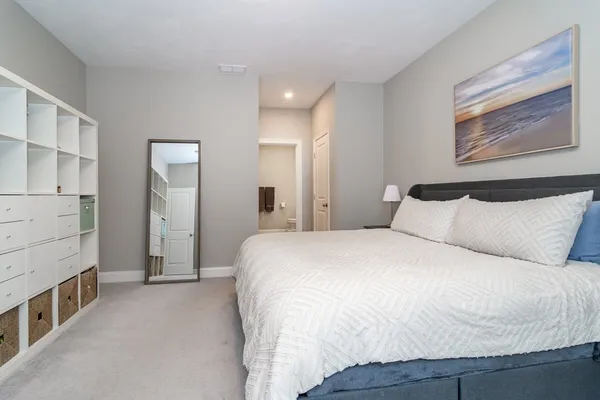 a spacious bedroom with a bed and a cabinets