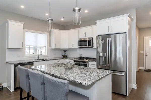 a kitchen with stainless steel appliances granite countertop a sink stove and refrigerator
