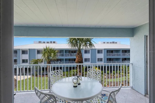 a view of a balcony with a dining table and chairs