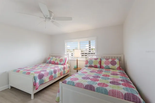 a bedroom with two beds and a lamp