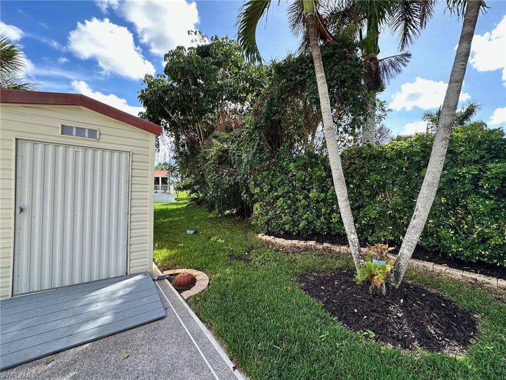 1275 Silver Lakes Boulevard Naples, FL 34114 - Photo 7 of 11 View of green lawn with a shed