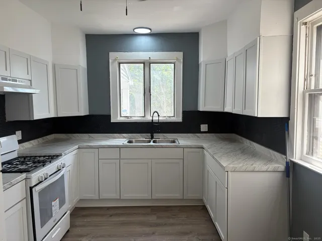 a kitchen with a sink and a stove top oven