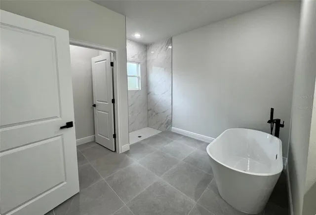 a spacious bathroom with a double vanity sink a mirror and a bathtub