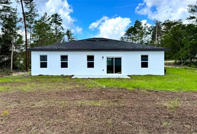 a view of a white house with a yard