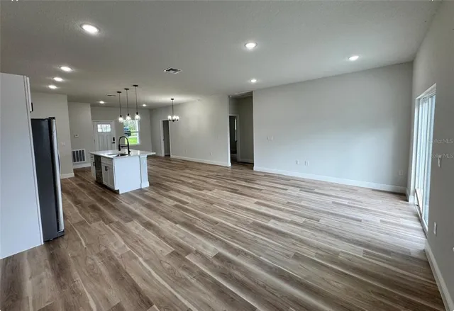 a view of a living room and kitchen with a wooden floor