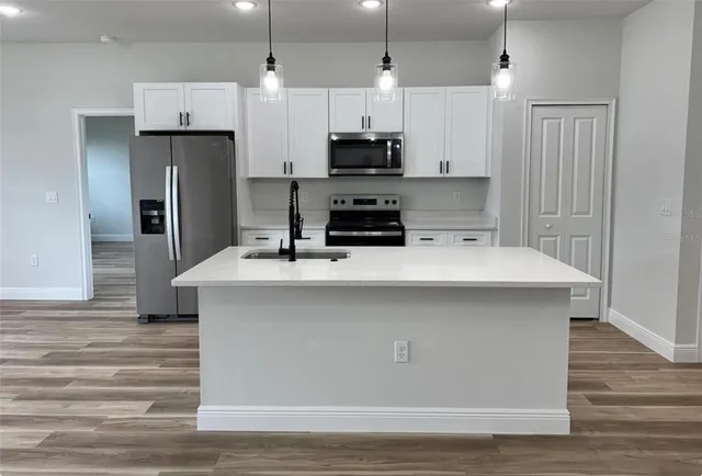 a view of a big room with wooden floor and a window