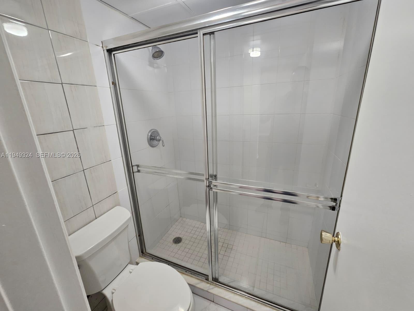 642 Northwest 13th Street, Unit 310 Boca Raton, FL 33486 - Photo 17 of 32 a bathroom with a shower and a toilet