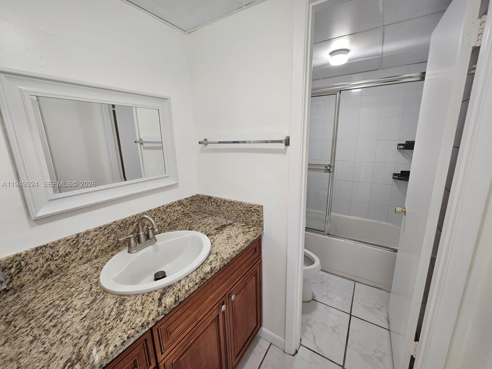 642 Northwest 13th Street, Unit 310 Boca Raton, FL 33486 - Photo 22 of 32 a bathroom with a sink and a mirror