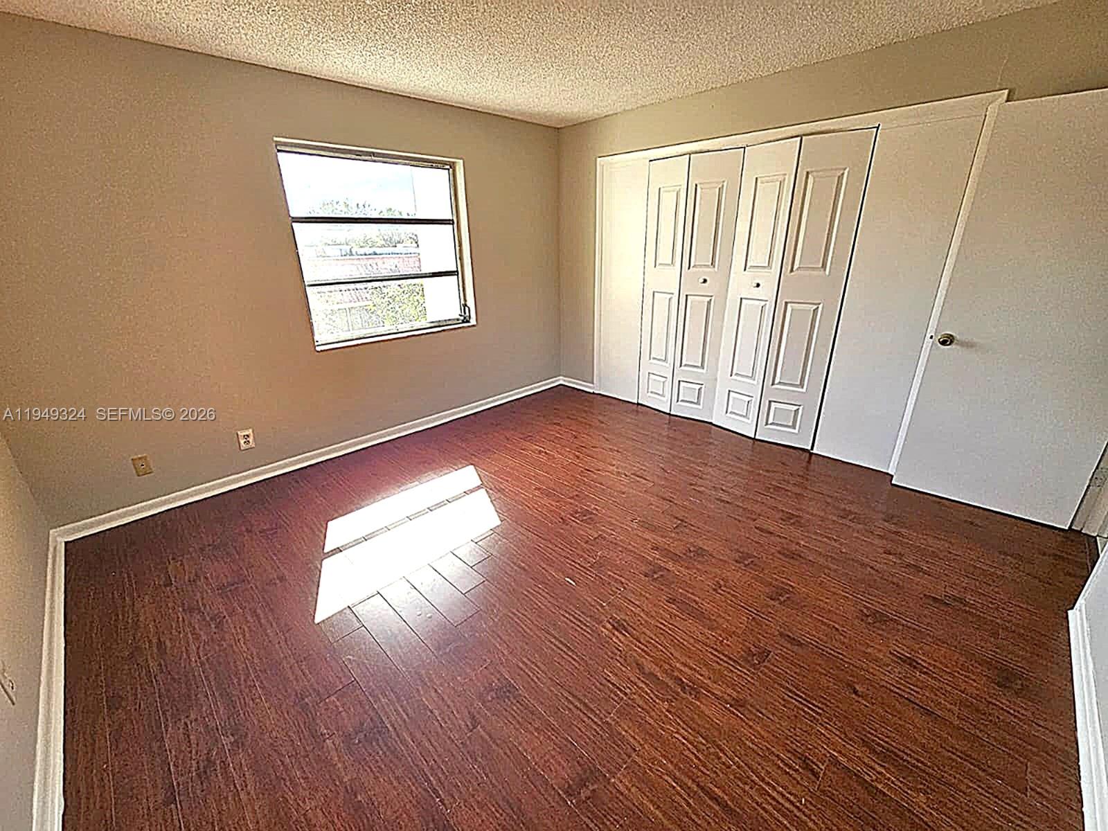 642 Northwest 13th Street, Unit 310 Boca Raton, FL 33486 - Photo 25 of 32 an empty room with wooden floor and windows