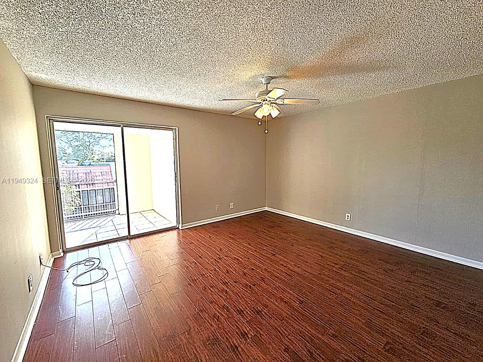 642 Northwest 13th Street, Unit 310 Boca Raton, FL 33486 - Photo 10 of 32 an empty room with wooden floor and windows
