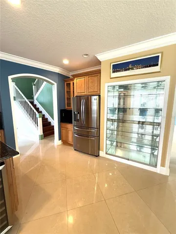 a kitchen with stainless steel appliances granite countertop a refrigerator a stove a sink and a large window