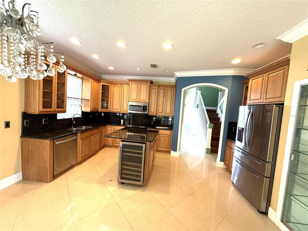 3865 Northwest Deer Oak Drive Jensen Beach, FL 34957 - Photo 12 of 34 a kitchen with stainless steel appliances granite countertop a refrigerator a stove a sink and a large window