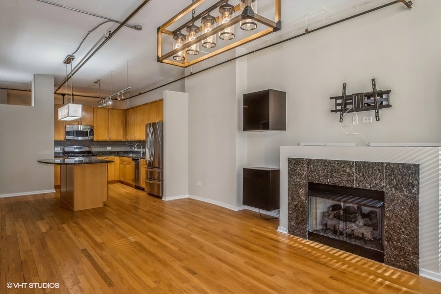 520 South State Street, Unit 702 Chicago, IL 60605 - Photo 5 of 20 a living room with stainless steel appliances furniture a fireplace and flat screen tv