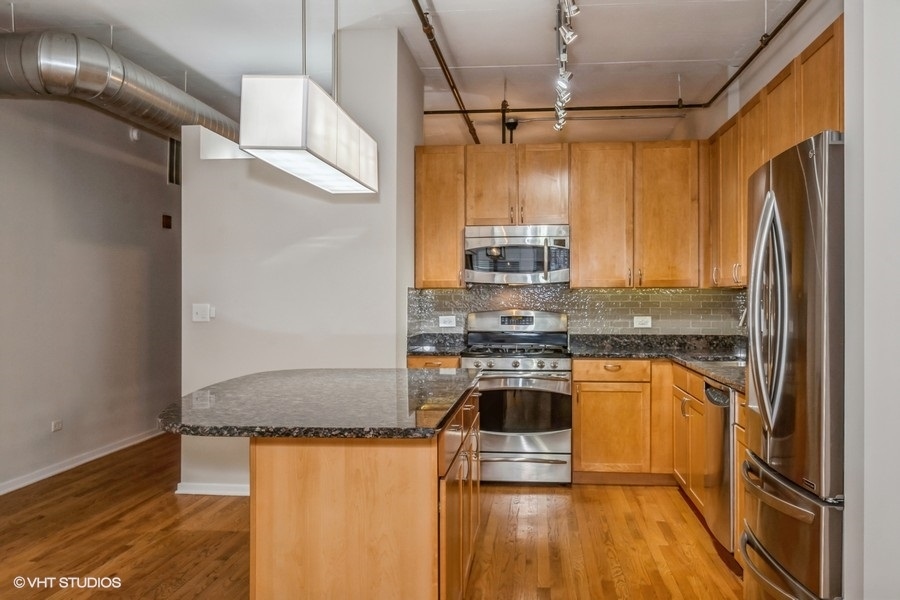 520 South State Street, Unit 702 Chicago, IL 60605 - Photo 8 of 20 a kitchen with stainless steel appliances granite countertop a refrigerator a stove and a wooden floors
