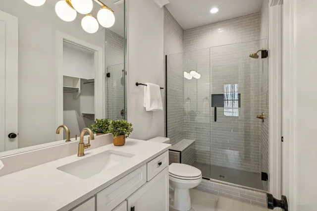 a bathroom with a sink toilet a mirror and shower