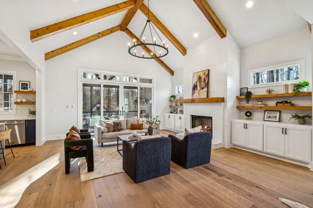 a living room with furniture fireplace and a large window