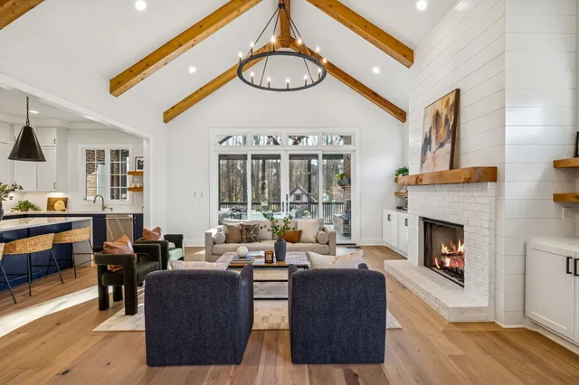 a living room with furniture a fireplace and a large window