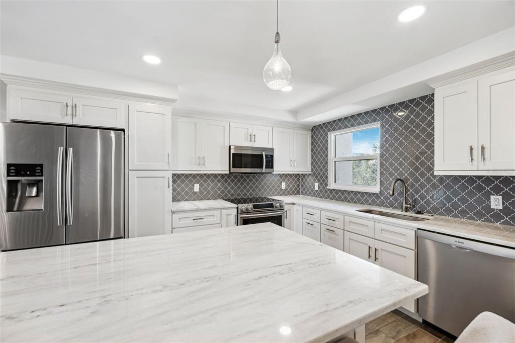 105 4th Avenue Northeast, Unit 418 St. Petersburg, FL 33701 - Photo 11 of 42 a kitchen with stainless steel appliances a stove refrigerator sink and microwave