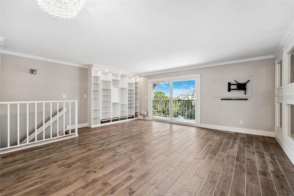 105 4th Avenue Northeast, Unit 418 St. Petersburg, FL 33701 - Photo 13 of 42 a view of an empty room with wooden floor and a window