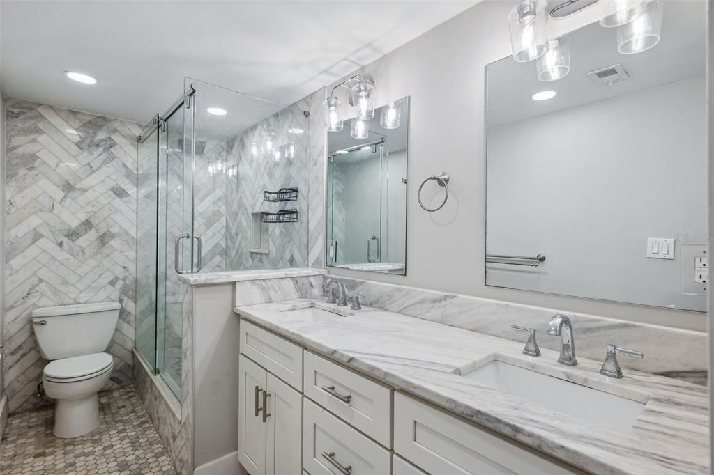 105 4th Avenue Northeast, Unit 418 St. Petersburg, FL 33701 - Photo 21 of 42 a bathroom with a granite countertop sink a toilet and a mirror
