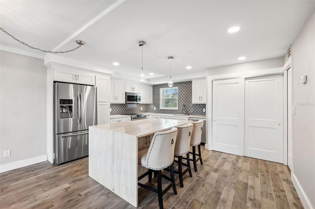 105 4th Avenue Northeast, Unit 418 St. Petersburg, FL 33701 - Photo 6 of 42 a kitchen with stainless steel appliances granite countertop a refrigerator a sink dishwasher a stove and a refrigerator with wooden floor