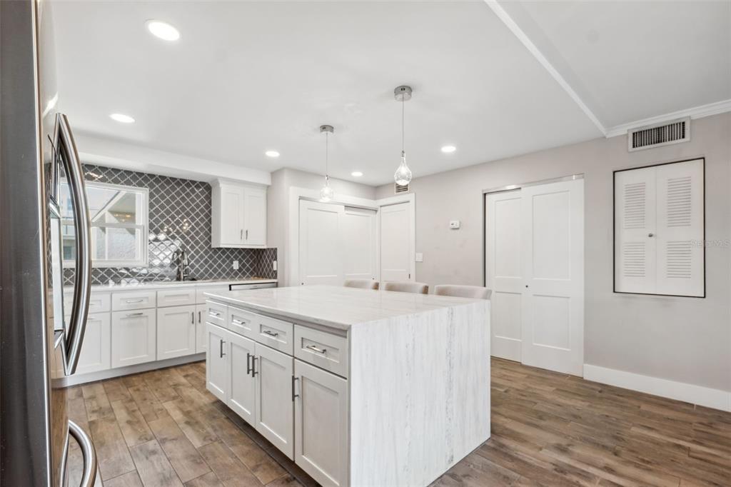 105 4th Avenue Northeast, Unit 418 St. Petersburg, FL 33701 - Photo 9 of 42 a large white kitchen with stainless steel appliances granite countertop a stove and a refrigerator