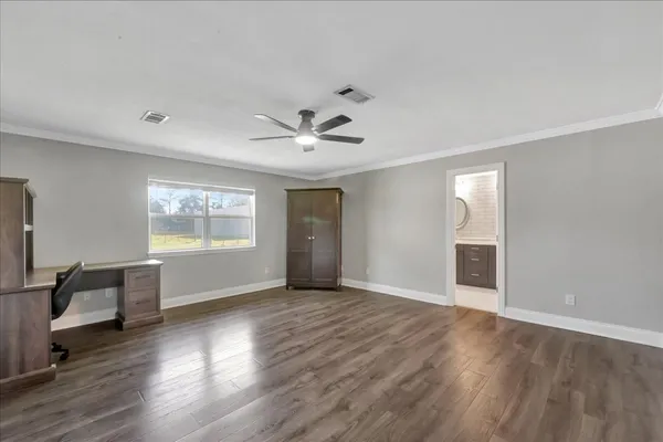 a view of an empty room with a window and wooden floor