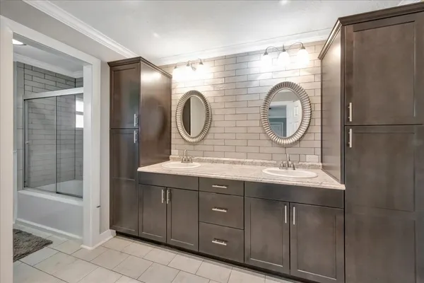 a bathroom with a double vanity sink mirror and shower