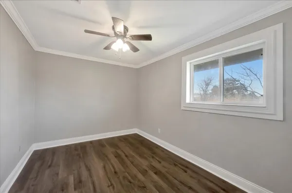 a view of wooden floor and chandelier fan in a room