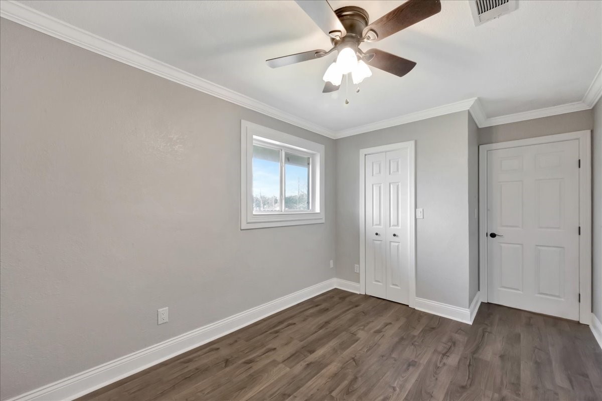 12335 2nd Street Santa Fe, TX 77539 - Photo 31 of 49 an empty room with wooden floor ceiling fan and windows