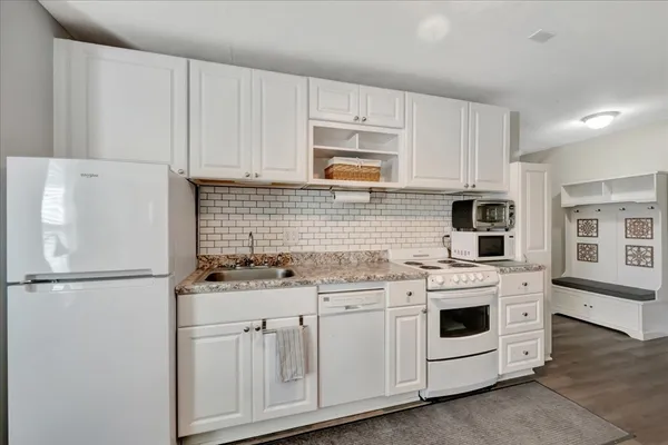 a kitchen with appliances a sink and cabinets