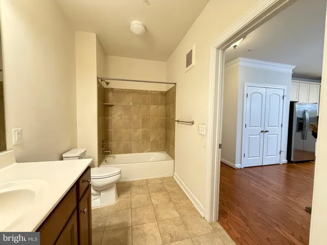 a bathroom with a granite countertop sink a toilet and shower