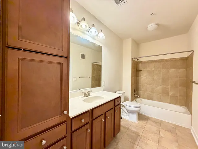 a bathroom with a sink a toilet a mirror and shower