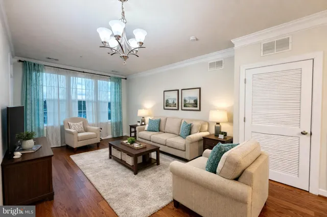 a living room with furniture or chandelier and a wooden floor