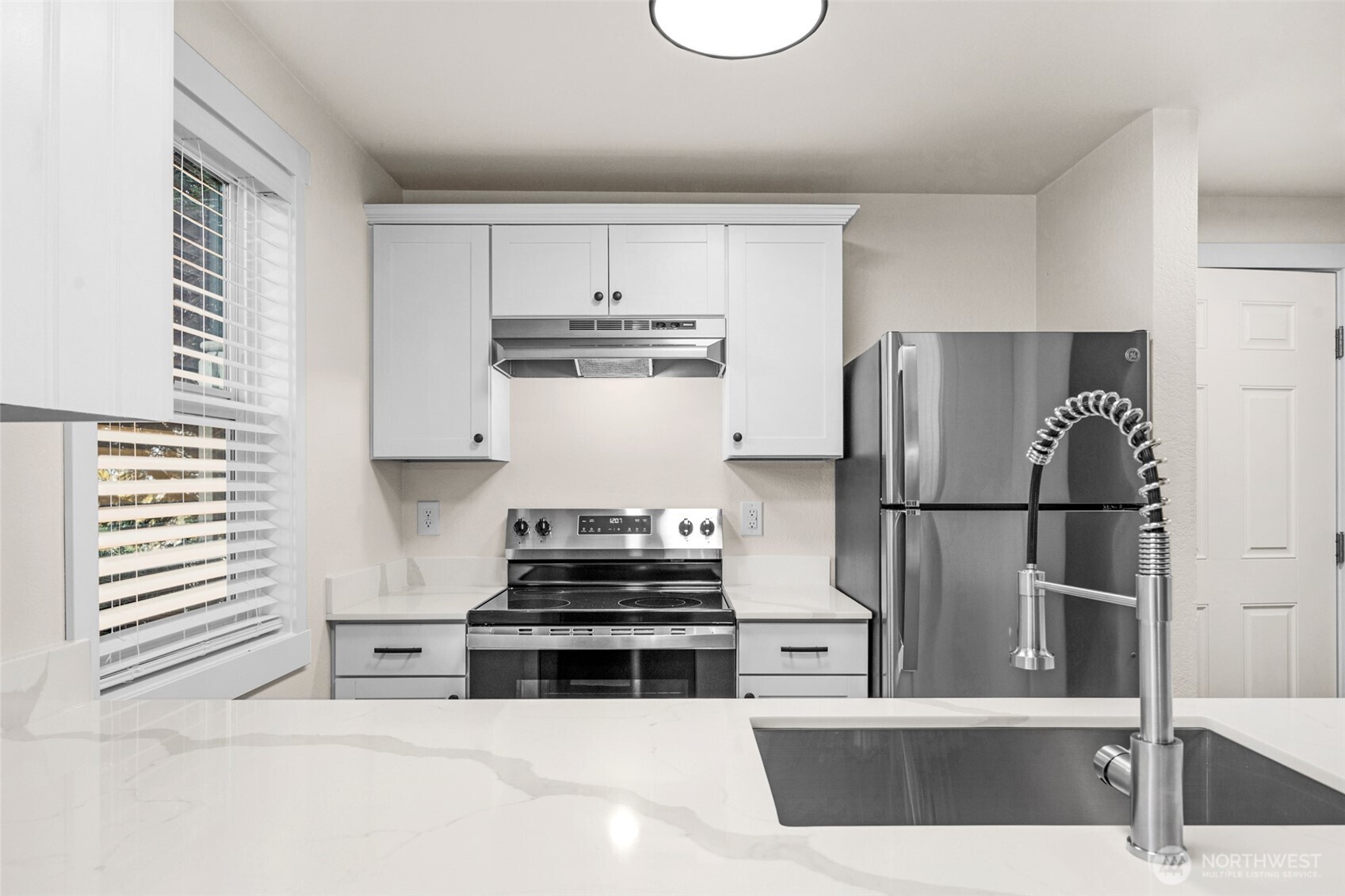 1302 Chestnut Street, Unit 2 Everett, WA 98201 - Photo 1 of 31 a kitchen with stainless steel appliances a refrigerator a stove and white cabinets