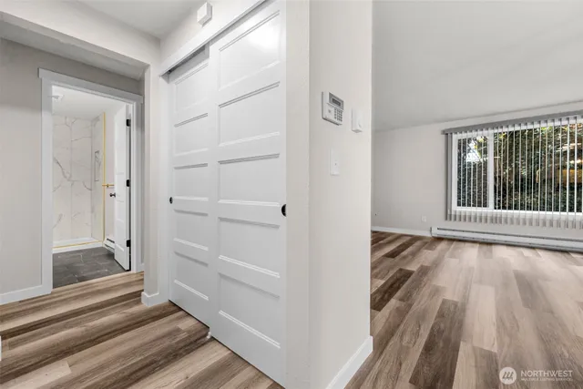 a view of a bedroom with wooden floor and windows